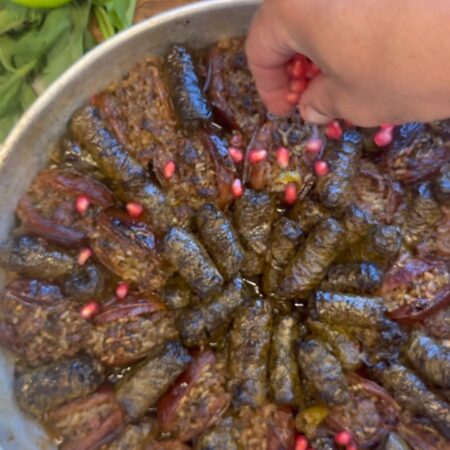 ⁨	הנה מנה שבאה לעשות לכם שמח בבטן ובנשמה 💃✨
עלי גפן ותמרים ממולאים עם בשר, אורז, עשבי תיבול ורימונים.מה צריך?שמן זית
2 כפות ממרח בצל נישוקים
עגבניות פרוסות + עגבניות מגורדות
עלי גפן חלוטים
תמרים מגולענים
אורז עגול
פטרוזיליה, נענע, שמיר
בשר בקר טחון
בצל מגורד
מיץ לימון
רכז רימונים
גרגרי רימון
מלח ופלפלאיך מכינים?מערבבים בקערה בצל מגורד, עגבניות מגורדות וממרח בצל נישוקים.
קוצצים את העלים הירוקים, מוסיפים את הבשר והתיבול ונותנים למסה לנוח קצת.משמנים תבנית ומסדרים עגבניות פרוסות בתחתית כך שיכסו את כל התבנית.חולטיים את עלי גפן במים חמים, מגלענים תמרים ומתחילים למלא. מסדרים יפה יפה בתבנית.מכינים רוטב: מים חמים, לימון, מלח ופלפל ושופכים מעל.מתיזים רכז רימונים, מכסים ושולחים לתנור לשעה אחרי בערך שעה, מוסיפים טיפונת שמן זית נותנים להם עוד 10 דקות, ומוכן
שיהיה בתאבון!⁩